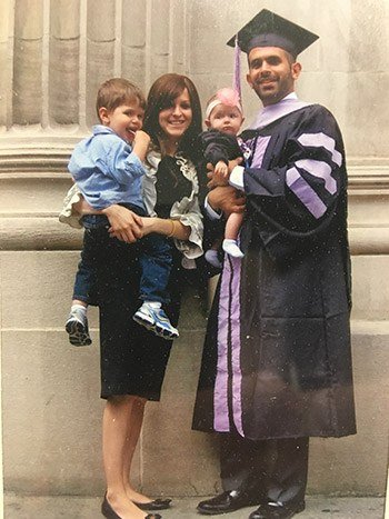 Dr. Milner in a graduation cap and gown with his family