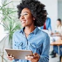 Smiling woman holding tablet in office