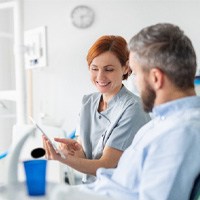 dental assistant talking to patient about sleep apnea treatment 