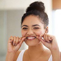 Woman flossing teeth