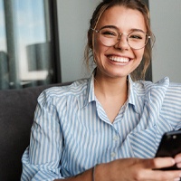 Young woman with dental implants in Owings Mills, MD on couch