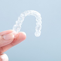 Patient holding up Invisalign clear aligner