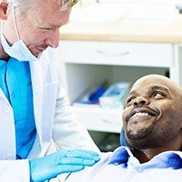 Man in dental chair smiling at dentist