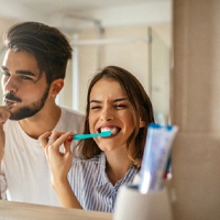 Couple brushing teeth in Owing Mills