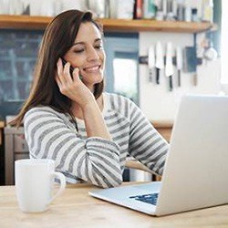 Woman looking at laptop and talking on phone