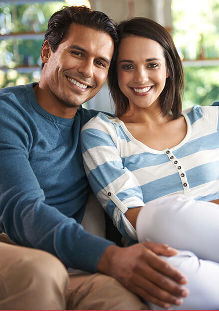Smiling man and woman on couch