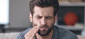 Man holding jaw in pain