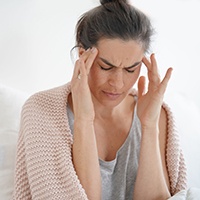 Woman with a headache due to TMJ issues 