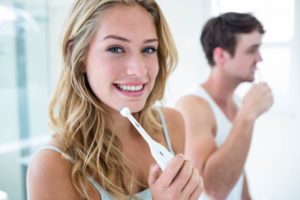 Couple brushing teeth using tips from dentist