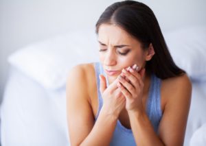 a person holding their mouth because their dental implant is sensitive