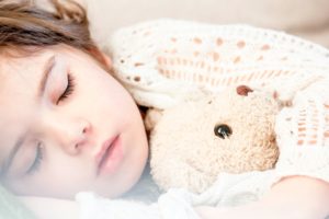 Young girl with teddy bear sleeping