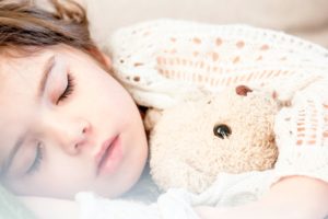 Young girl with teddy bear sleeping