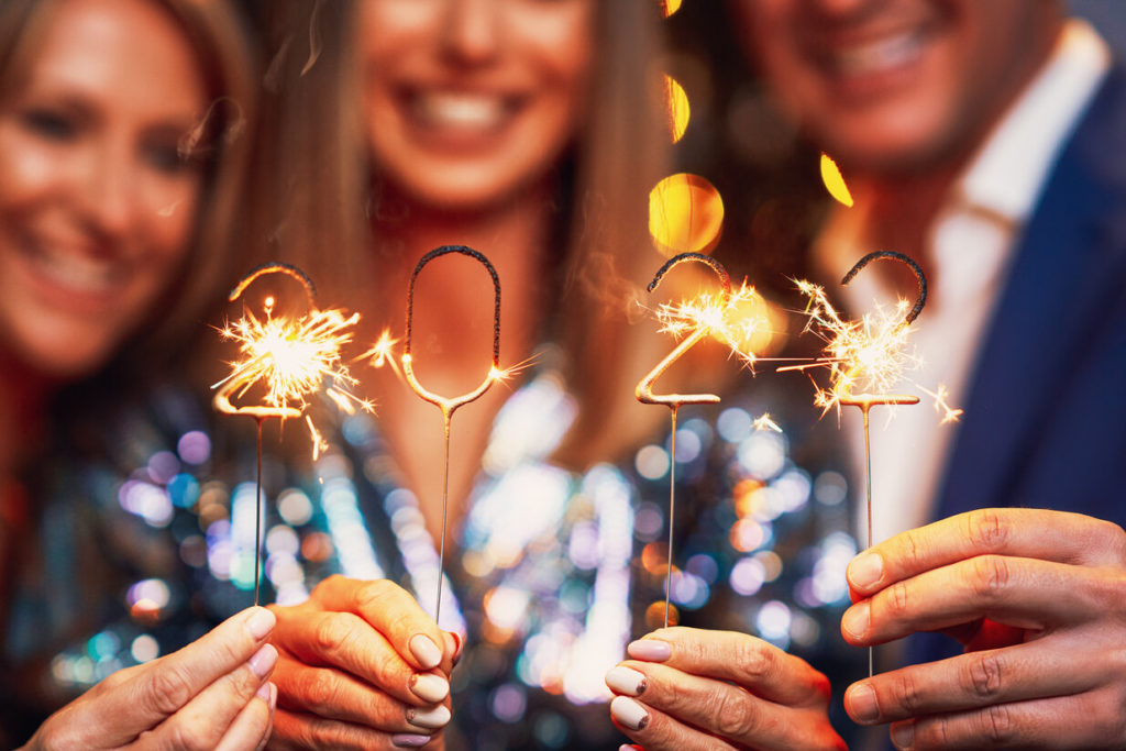people with New Year's resolution to floss more holding 2022 sparklers