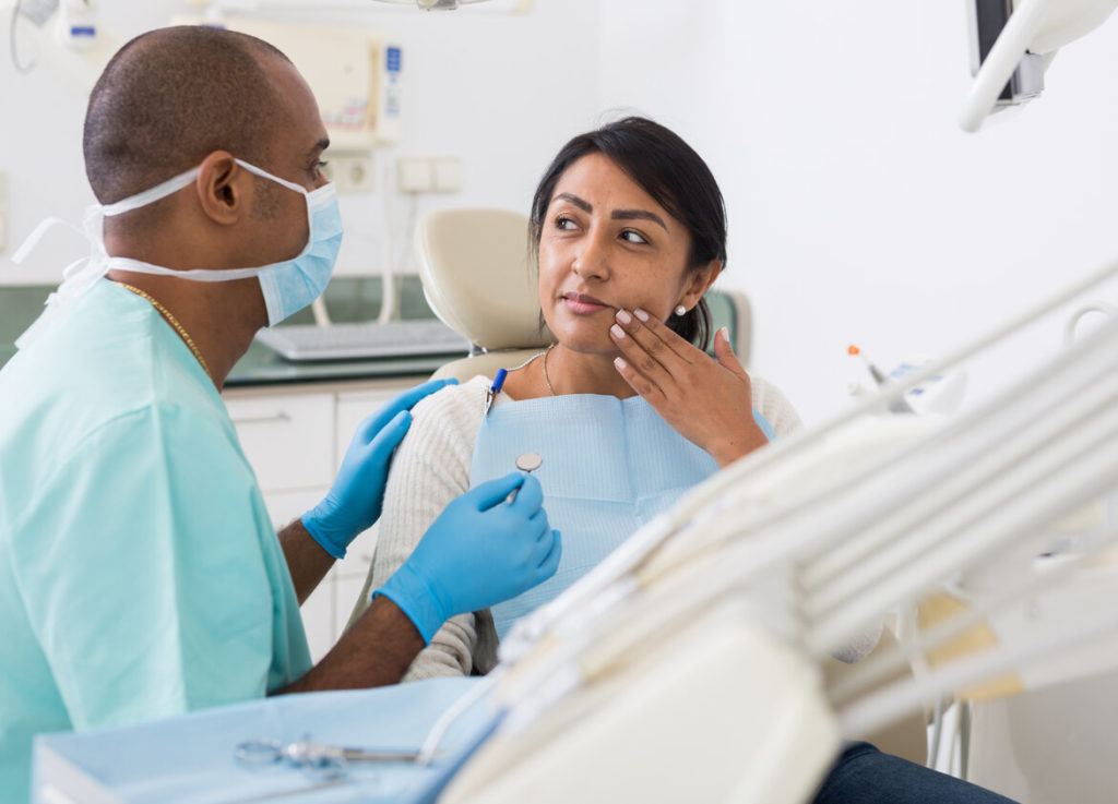 person asking dentist questions at dental implant consultation