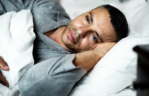 Man lying awake in bed at night