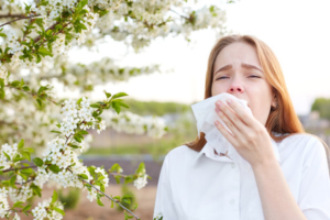 a woman sneezing during allergy season