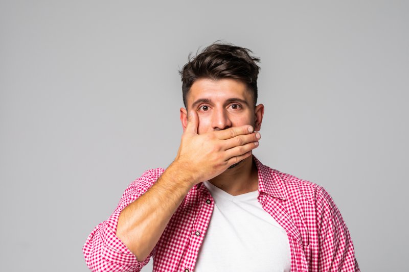 A man feeling embarrassed by his dental implants