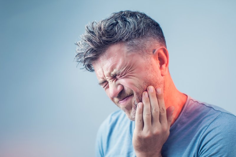 Man holds face in pain.